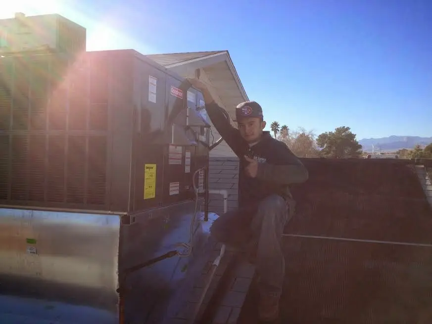 HVAC technician performing HVAC Inspection on a rooftop unit in Texas City